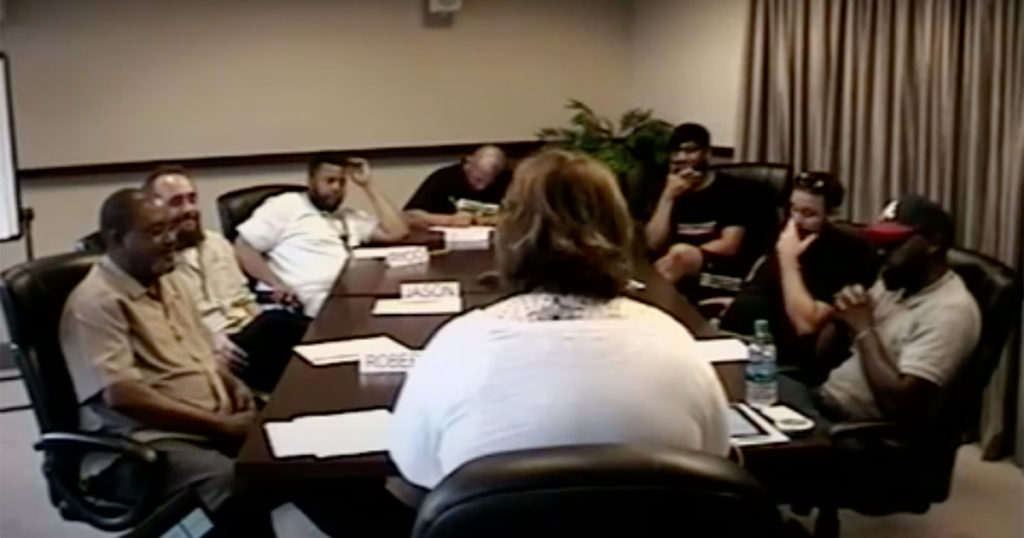 Seven electricians in a focus group sit around a conference room table.