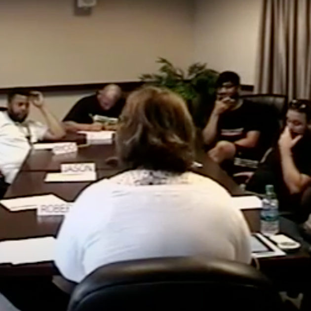Seven electricians in a focus group sit around a conference room table.